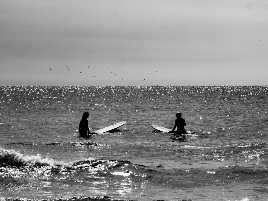 Surfers in the Glittering Sea